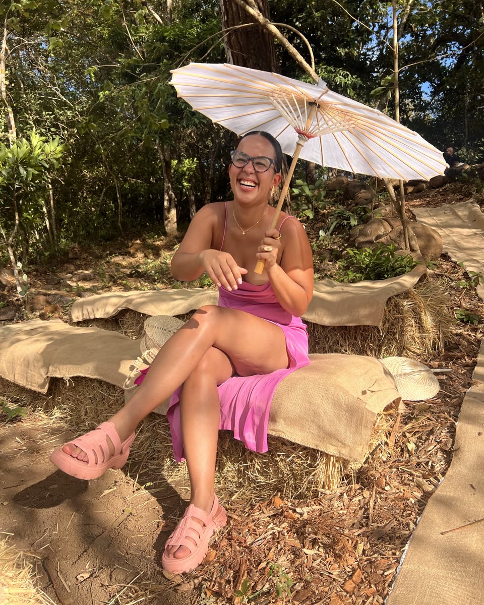 Indhira laughing outdoors under a paper parasol
